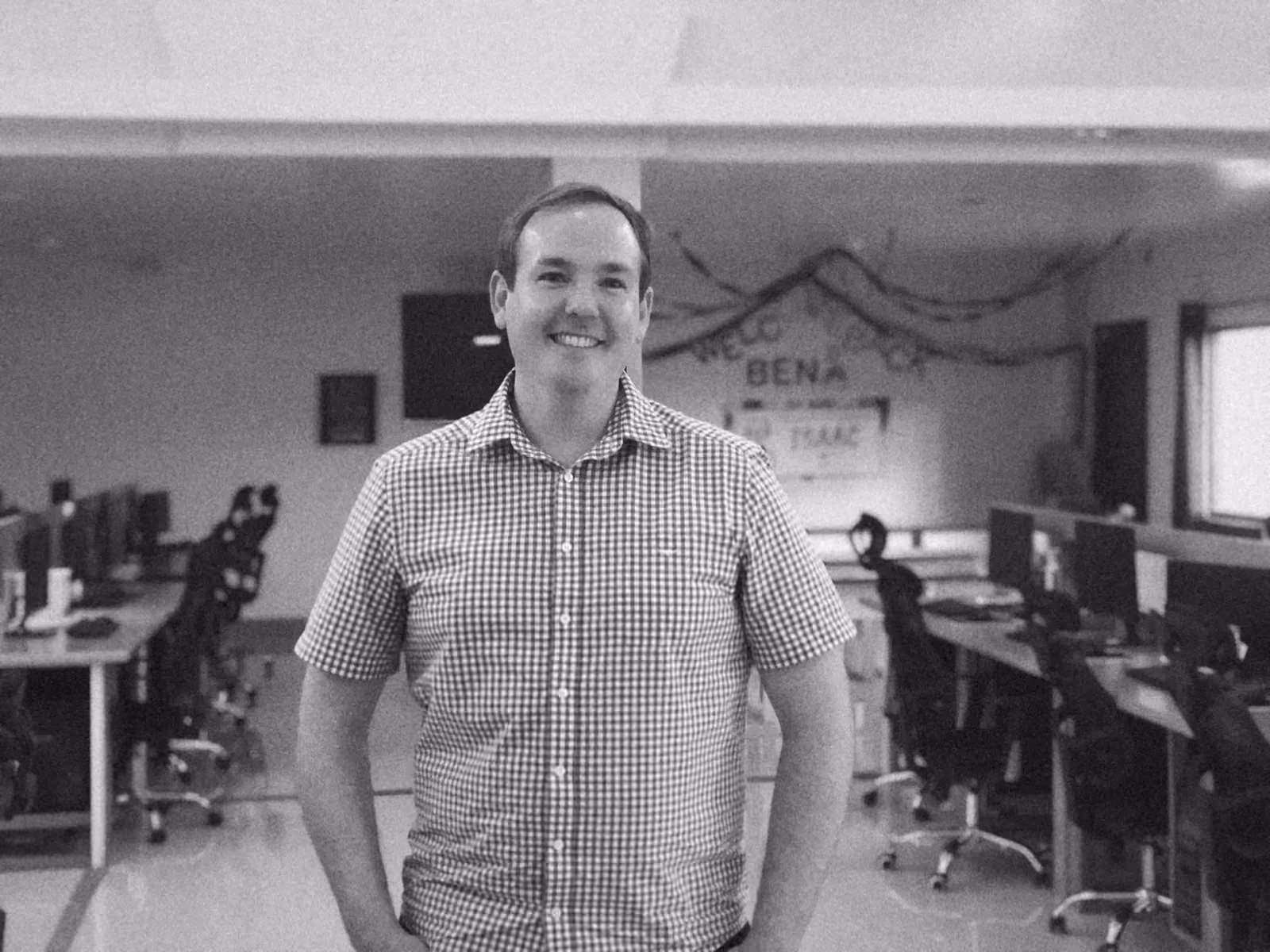 Ben standing in the fitted out office between rows of desks