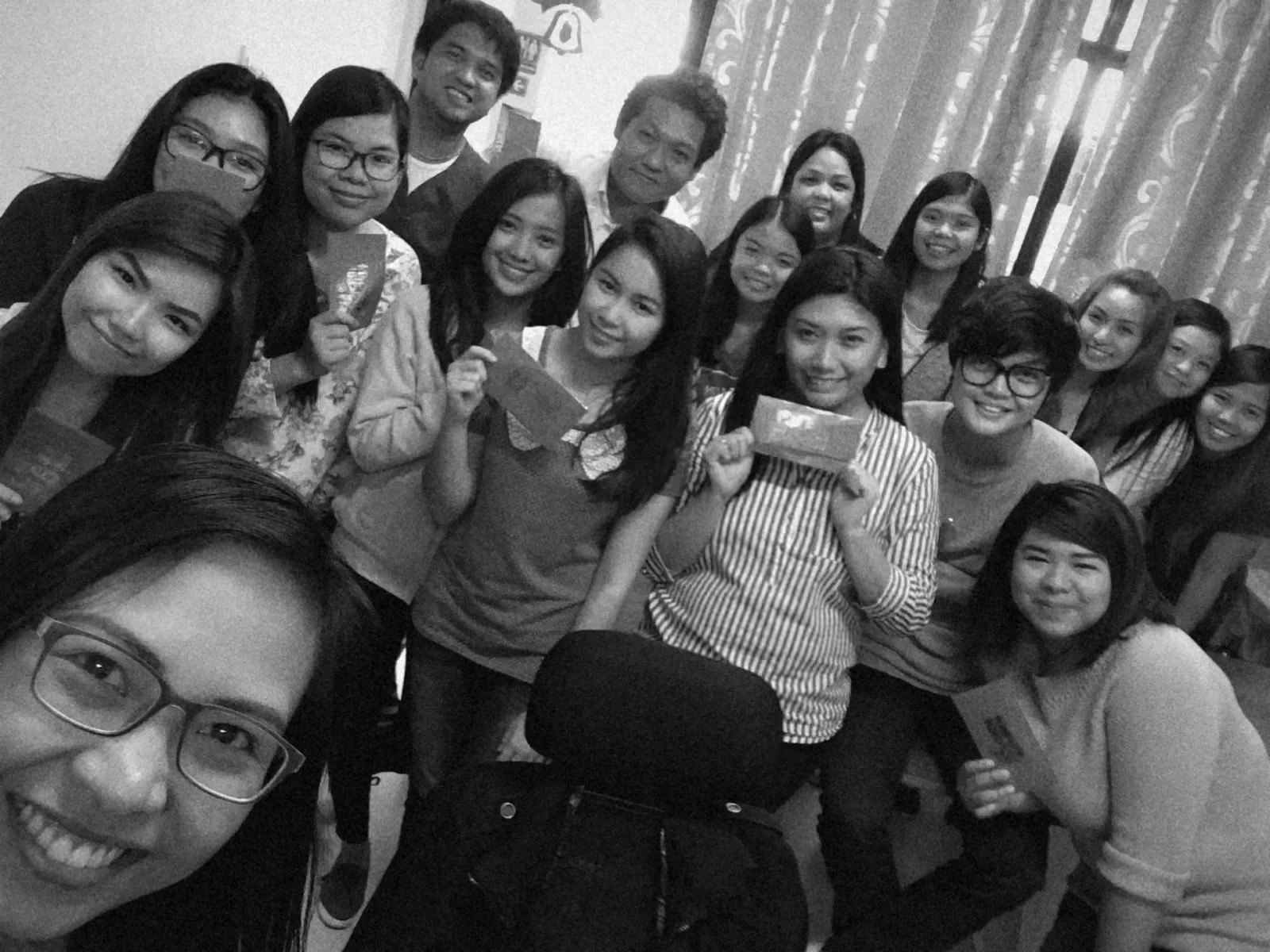 A crowded selfie of the office team holding red envelopes